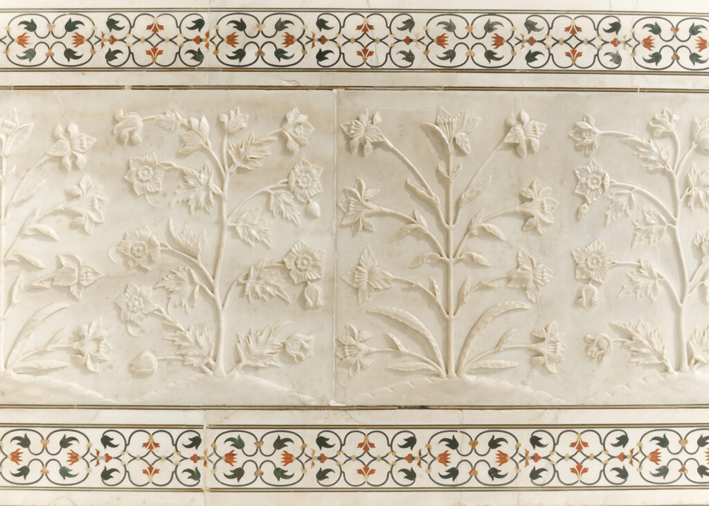 A close-up view of the intricate inlay work on the Taj Mahal's walls, featuring delicate floral motifs created using Pietra Dura technique.