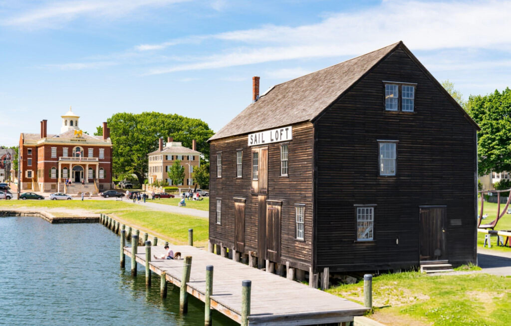 "Historic Pedrick Store House, a wooden structure with a gable roof and large doors, standing on the grounds of the Salem Maritime National Historic Site."