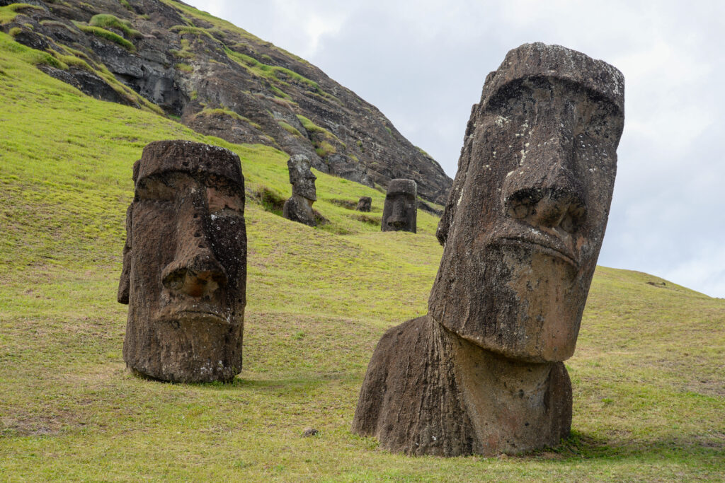 Rano Raraku quarry on Easter Island, with several Moai statues standing on the grassy slopes.